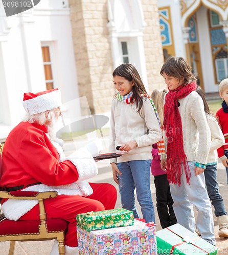 Image of Children Taking Biscuits From Santa Claus