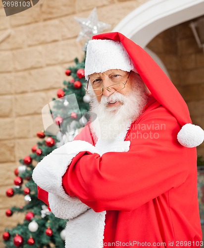 Image of Santa Clause Standing Arms Crossed Outside House