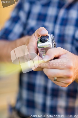 Image of Carpenter Holding Tape Measure