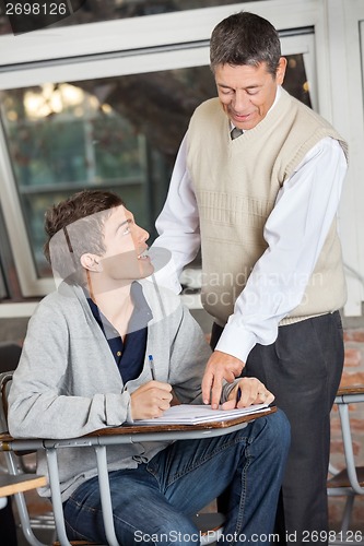 Image of Professor Explaining Exam To Student In Classroom