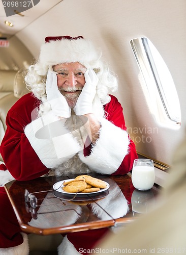 Image of Santa With Cookies And Milk Sitting In Private Jet