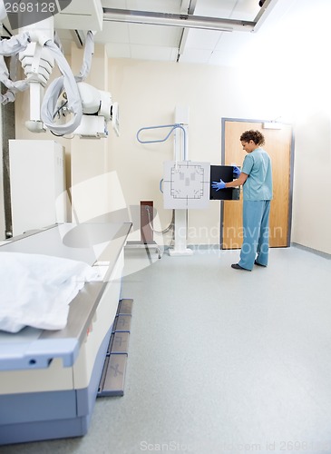 Image of Female Nurse Adjusting Xray Film In Machine