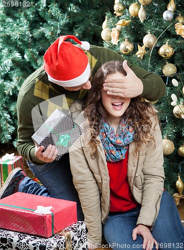 Image of Man Surprising Woman With Christmas Presents In Store