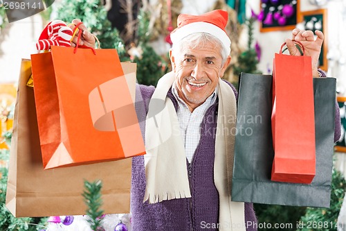 Image of Happy Man Carrying Shopping Bags In Christmas Store