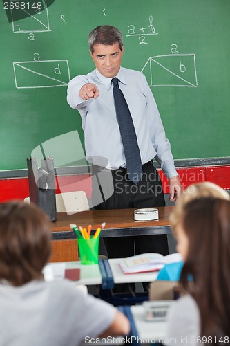 Image of Angry Teacher Pointing At Schoolboy In Classroom
