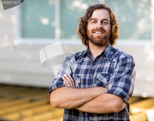 Image of Mid Adult Carpenter With Arms Crossed Standing At Construction S