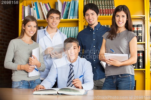 Image of Confident Librarian With Students In College Library