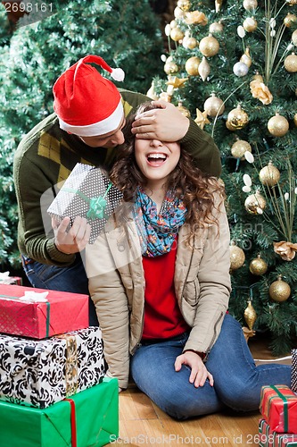 Image of Man Surprising Woman With Christmas Gifts In Store