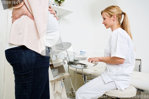 Image of Pregnant Woman With Doctor Using Ultrasound Machine