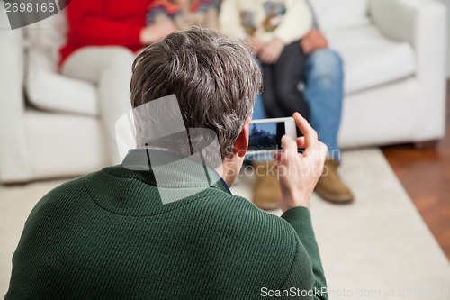 Image of Father Photographing Family Through Smartphone