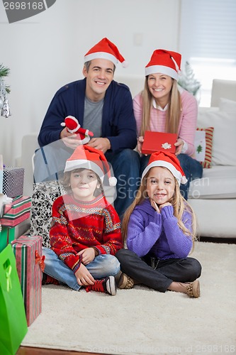 Image of Family In Santa Hats At Home During Christmas