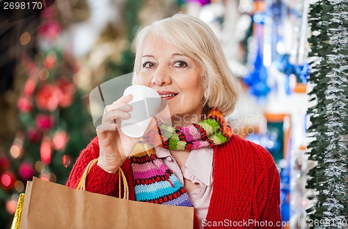 Image of Woman With Shopping Bags Drinking Coffee At Christmas Store