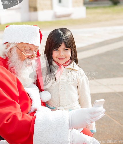 Image of Girl With Santa Claus Using Smartphone