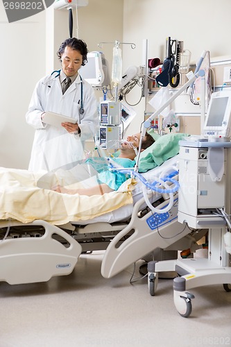 Image of Doctor With Digital Tablet Examining Patient's Report In Hospita