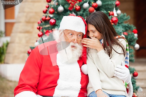 Image of Santa Claus Listening To Girl's Wish
