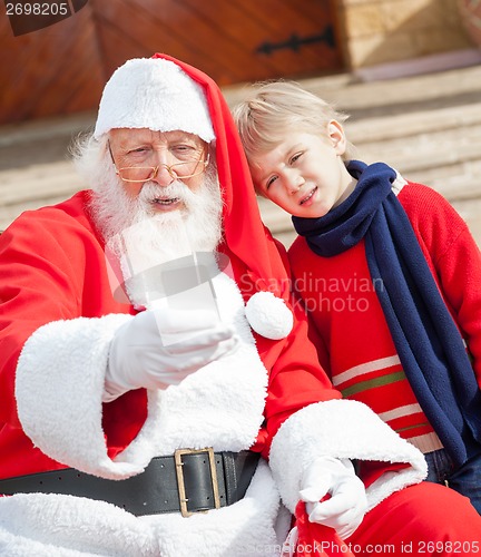 Image of Santa Claus And Boy Taking Selfportrait Through Smartphone