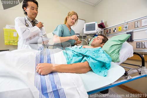 Image of Doctor And Nurse Examining Patient In Hospital