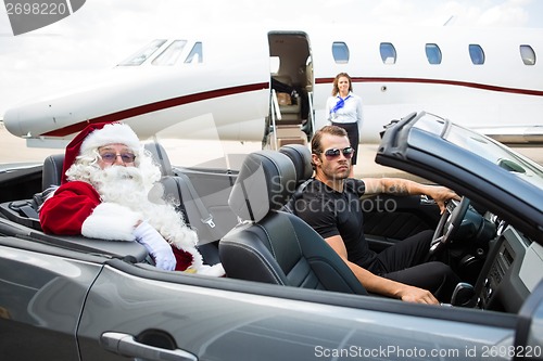 Image of Santa And Driver In Convertible With Jet in Background