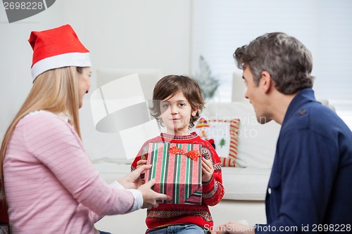 Image of Boy Taking Christmas Present From Mother