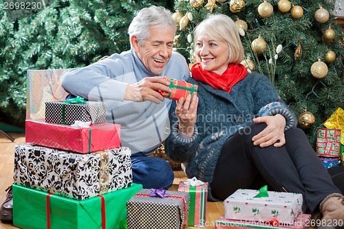 Image of Happy Couple With Presents Sitting In Christmas Store