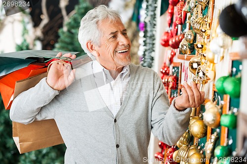 Image of Senior Man Buying Christmas Ornaments At Store