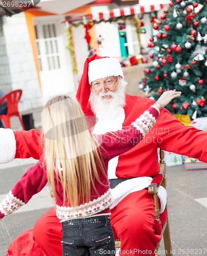 Image of Santa Claus And Girl About To Embrace