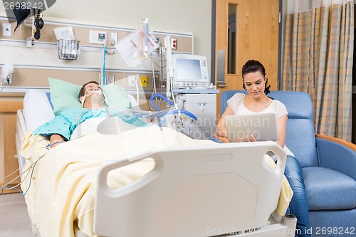 Image of Woman Using Digital Tablet While Sitting By Patient