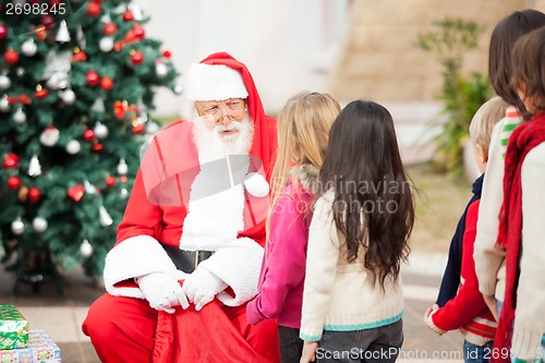 Image of Santa Claus Looking At Children Standing In A Queue