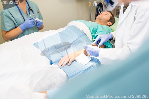 Image of Doctor Stitching Male Patient's Wound