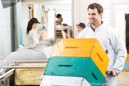 Image of Beekeeper Holding Trolley Of Stacked Honeycomb Crates