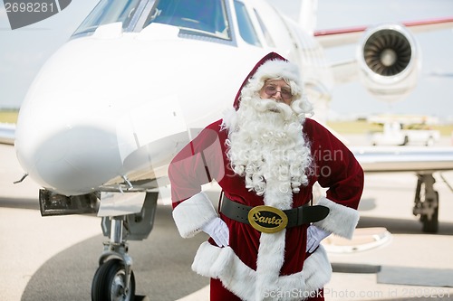 Image of Santa With Hands On Hip Against Private Jet