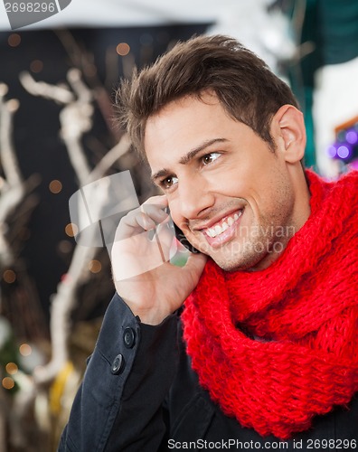 Image of Man Using Mobilephone In Christmas Store