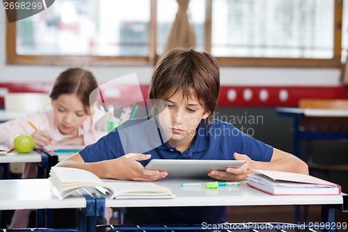 Image of Schoolboy Using Digital Tablet At Desk