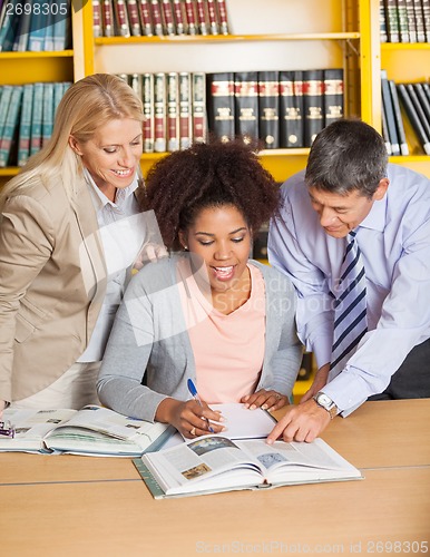 Image of Teachers Assisting Student In College Library