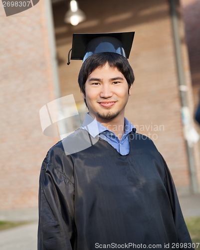 Image of Male Student In Graduation Gown And Mortar Board On Campus