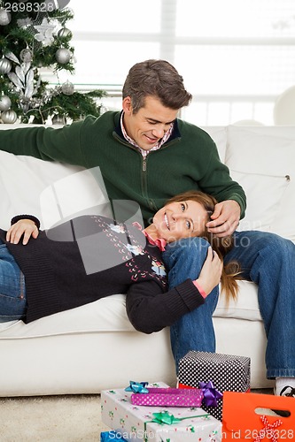 Image of Couple With Christmas Gifts On Floor Relaxing On Sofa