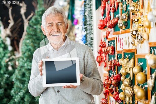 Image of Happy Man Holding Digital Tablet In Christmas Store