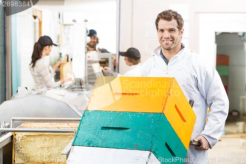 Image of Handsome Beekeeper With Trolley Of Stacked Honeycomb Crates