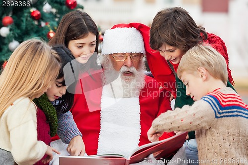 Image of Children And Santa Claus Reading Book