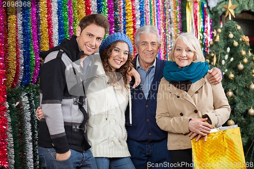 Image of Family Standing Against Tinsels At Christmas Store