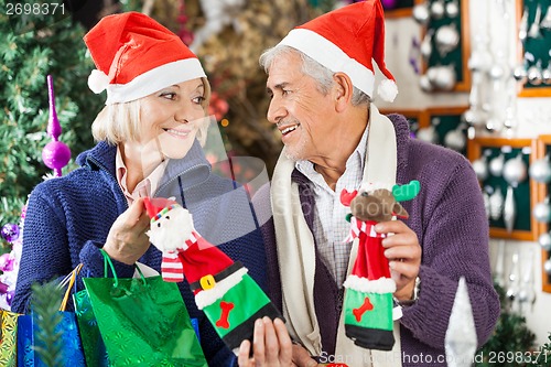 Image of Couple Shopping For Christmas Decorations In Store