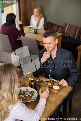 Image of Businessman Having Food With Female Colleague