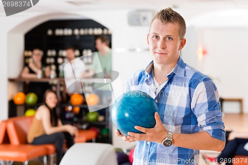 Image of Man Holding Bowling Ball in Club