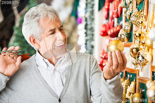 Image of Man Buying Christmas Baubles At Store