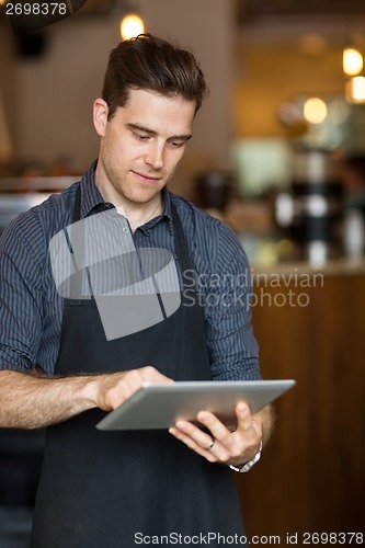 Image of Male Owner Using Digital Tablet