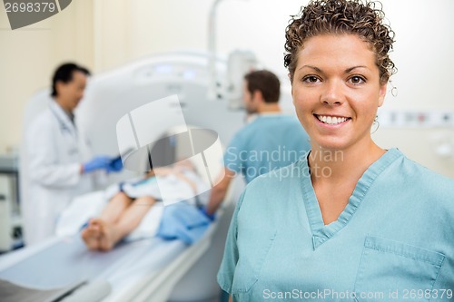 Image of Nurse With Colleague And Doctor Preparing Patient For CT Scan