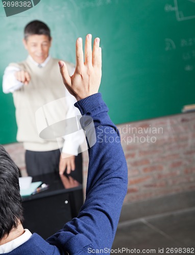 Image of Student Raising Hand To Answer Question In Classroom