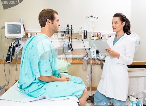 Image of Doctor Holding Clipboard While Discussing Report With Patient