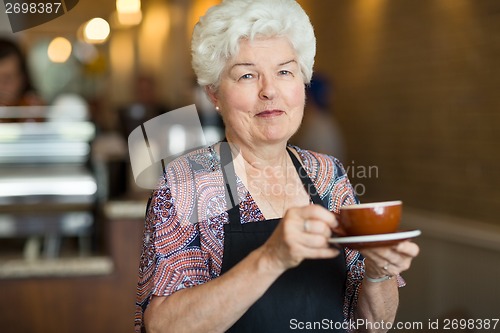 Image of Waitress Holding Coffee Cup And Saucer In Cafe