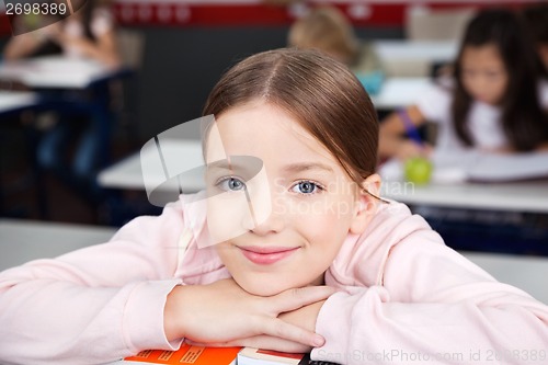 Image of Schoolgirl Resting Chin On Hands In Classroom